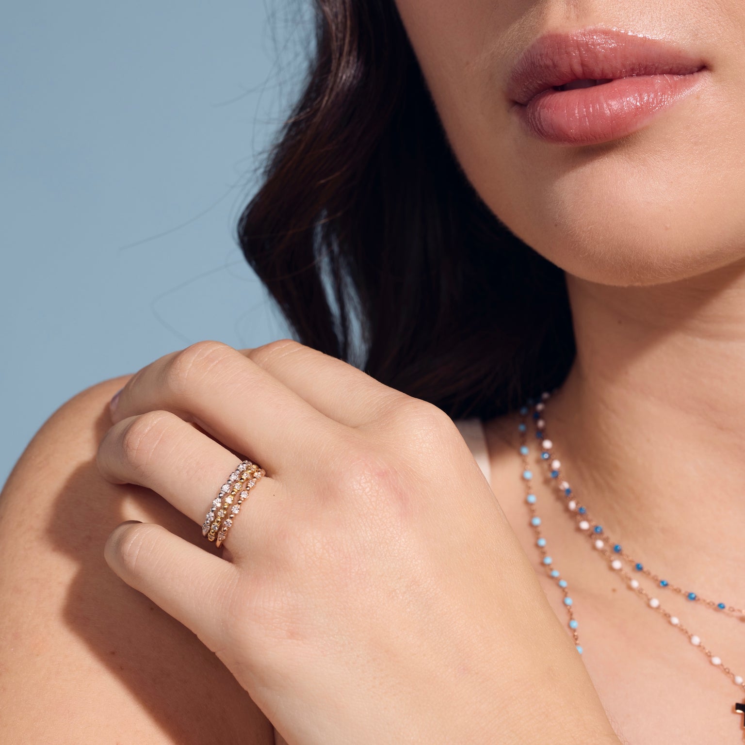Photo d’une femme portant aux doigts des bagues Gigi Clozeau serties de plusieurs diamants.