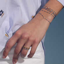 Photo du poignet d’une femme portant des bracelets Gigi Clozeau de la nouvelle couleur azur.