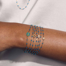 Photo du poignet d’une femme portant des bracelets Gigi Clozeau de la nouvelle couleur azur.