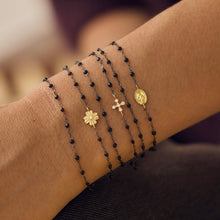 Poignet d’une femme portant différents bracelets de la nouvelle collection en or noir Gigi Clozeau.