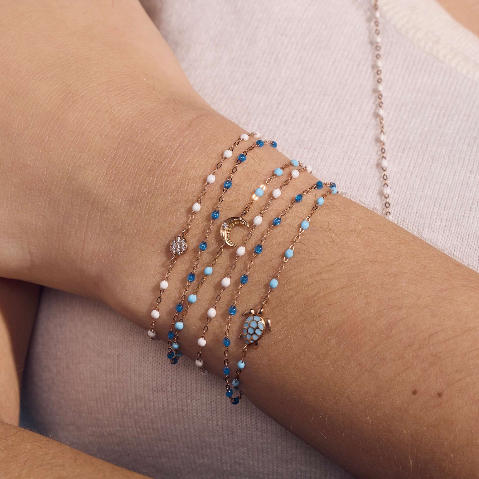 Photo du poignet d’une femme portant différents bracelets Gigi Clozeau.