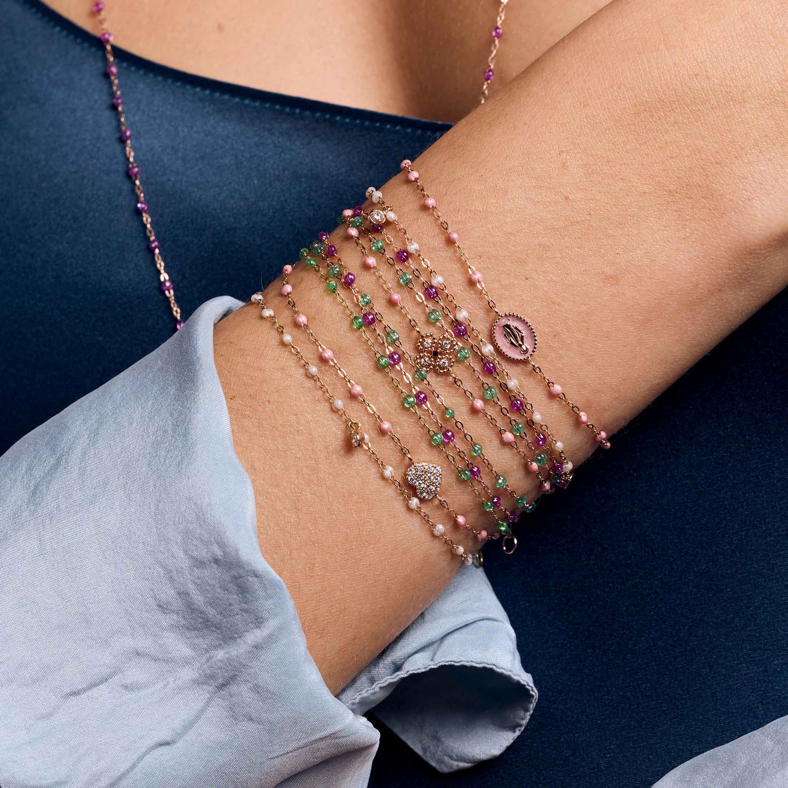 Photo du poignet d’une femme portant des bracelets Gigi Clozeau de différents modèles et couleurs.