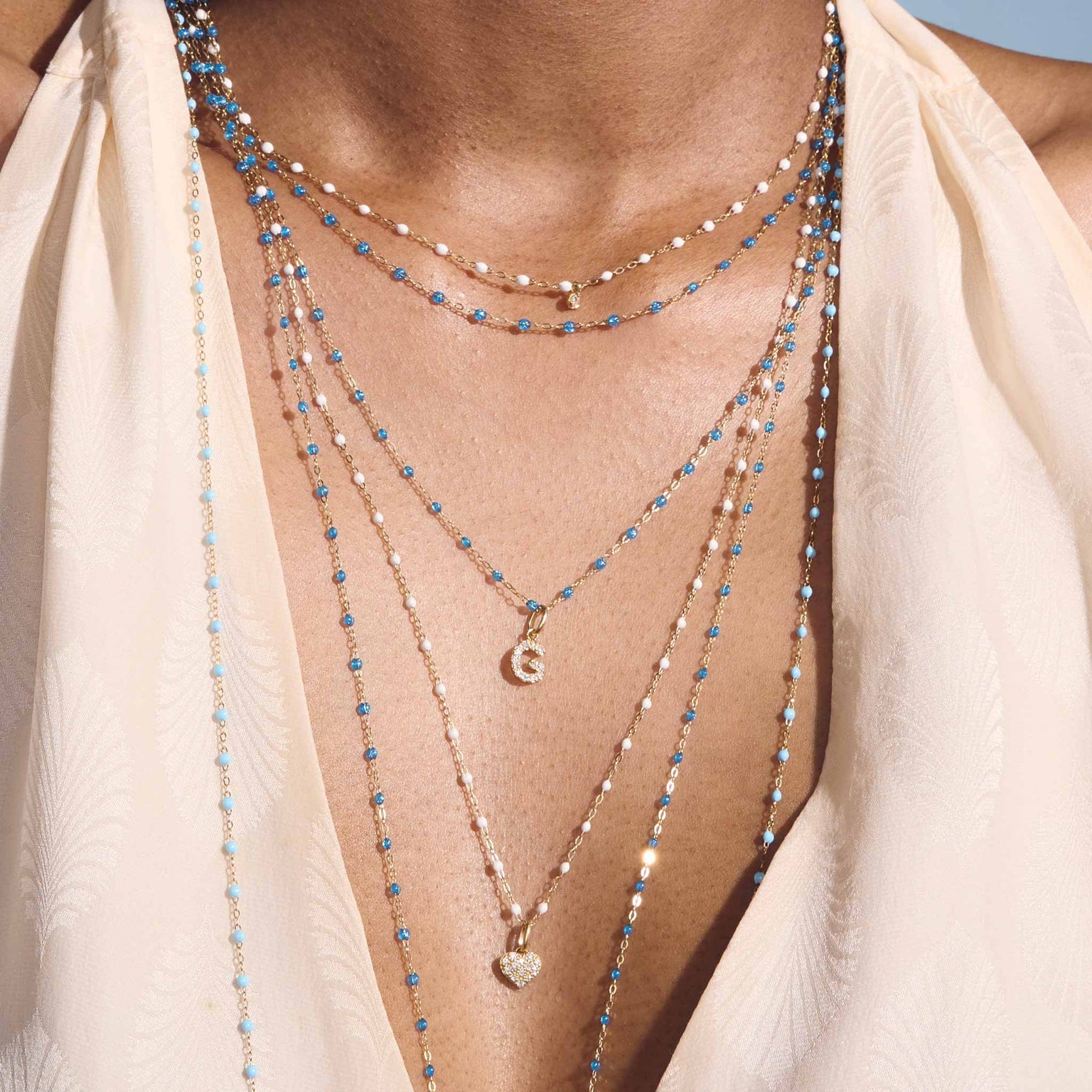 Photo du cou d’une femme portant différents colliers Gigi Clozeau.