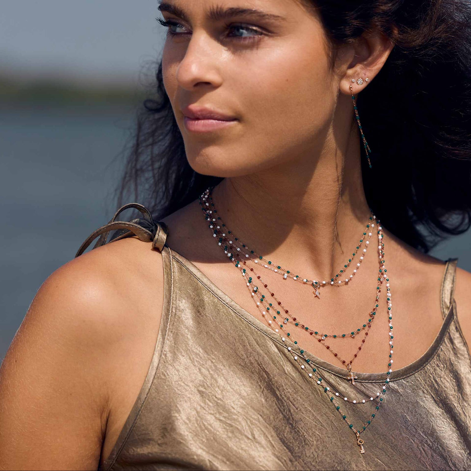 Photo d’une femme portant plusieurs colliers de différentes couleurs et modèles de Gigi Clozeau.