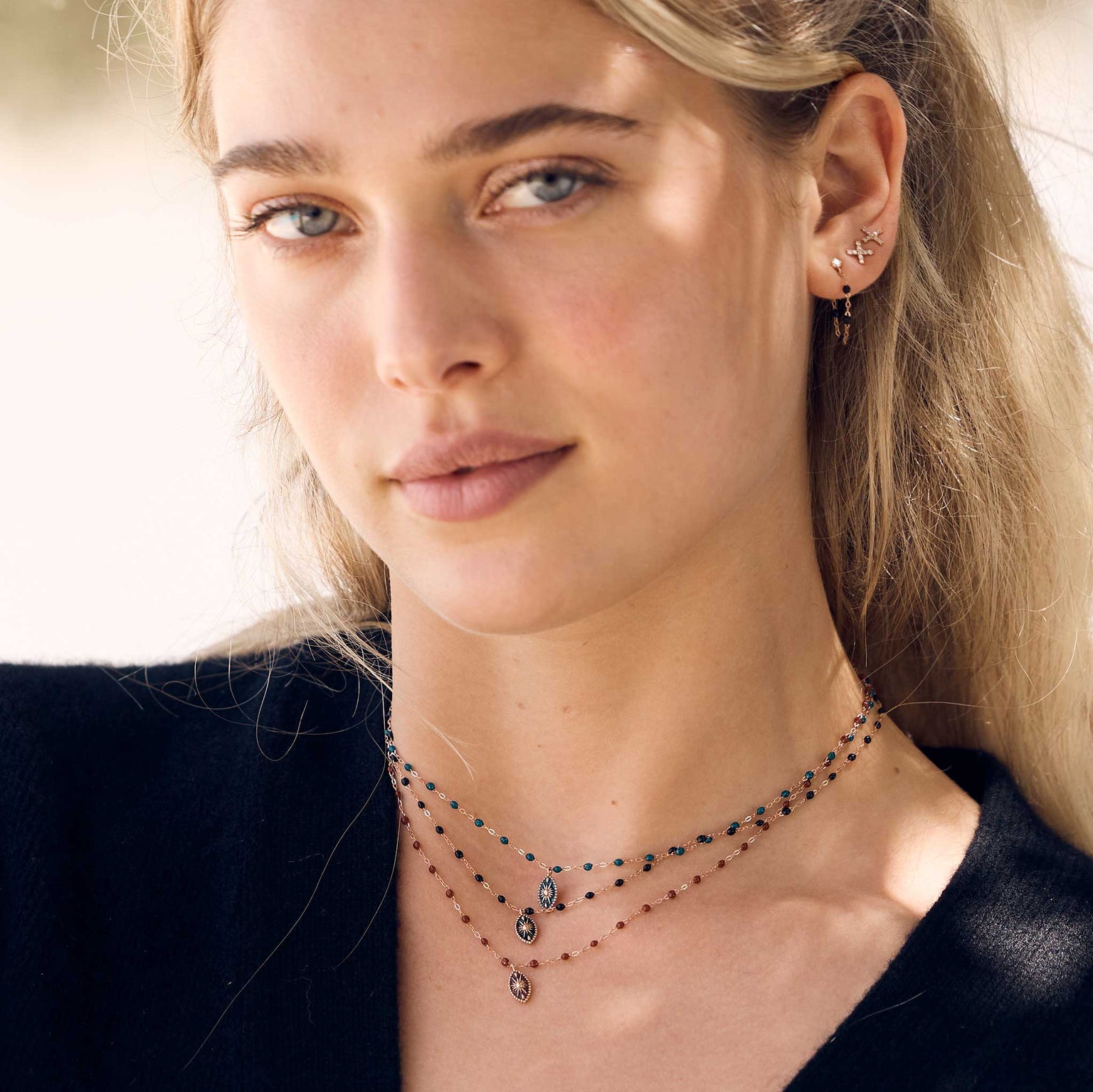 Photo d’une femme portant autour du cou des colliers Gigi Clozeau de la collection Karma.