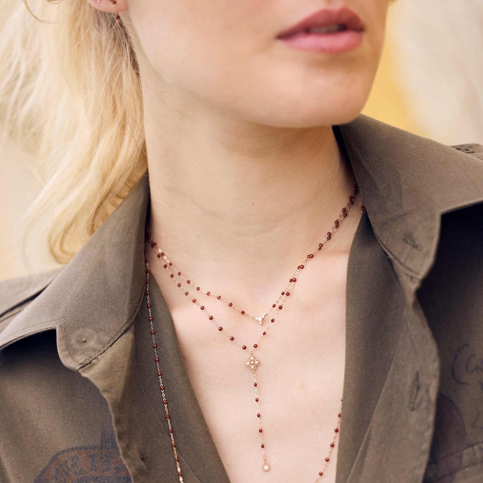 Photo d’une femme portant des colliers Gigi Clozeau de couleur moka. 