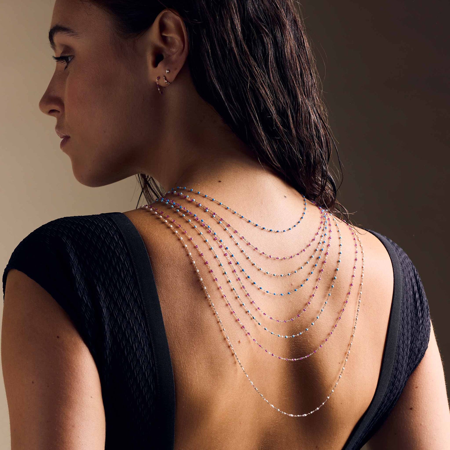 Photo du dos d'une femme avec des colliers Gigi Clozeau suspendus 