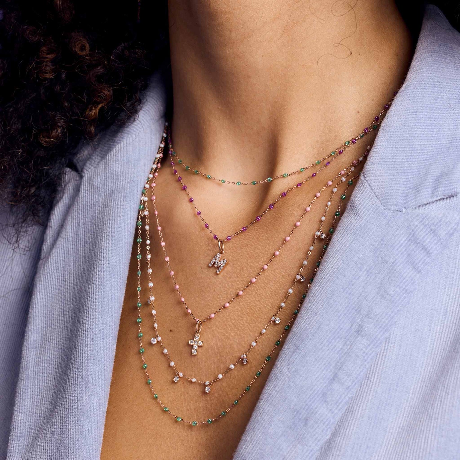Photo du cou d’une femme portant des colliers Gigi Clozeau de différentes couleurs.